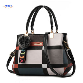 Cute pom-pom tassel accent on handbag with varied color shading.
