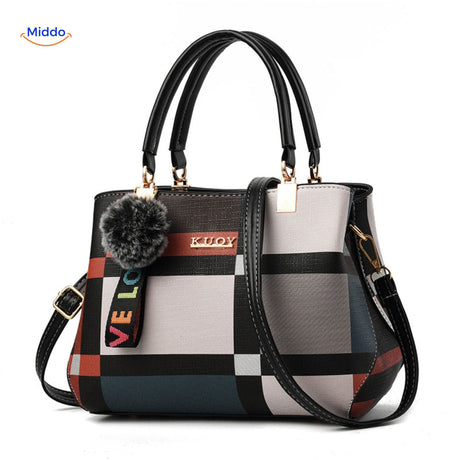 Cute pom-pom tassel accent on handbag with varied color shading.