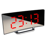 Close-up of red LED display showing time 23:13 on curved digital alarm clock.
