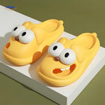 Cute yellow dog slippers with playful cartoon face details.