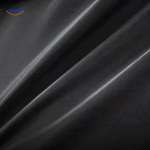 Close-up of the black wool coat fabric showing the dense, premium wool texture and weave.