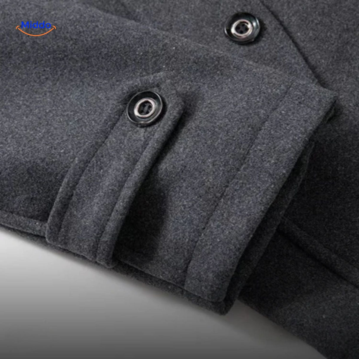 Close-up of the sleeve cuff detail on the grey wool coat, showing stitching and button finish.