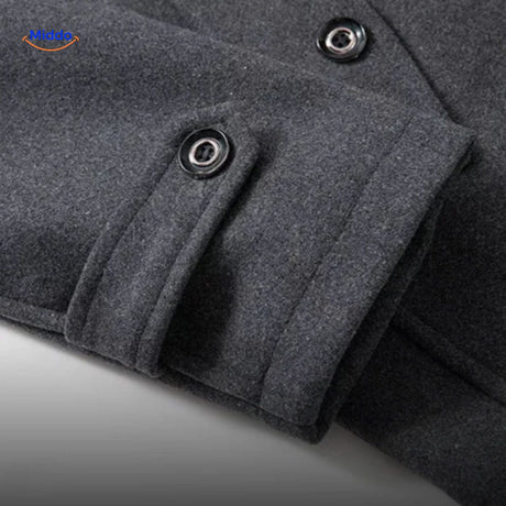 Close-up of the sleeve cuff detail on the grey wool coat, showing stitching and button finish.