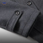 Close-up of the sleeve cuff detail on the grey wool coat, showing stitching and button finish.