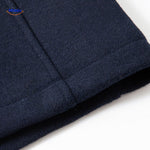Macro close-up of the dark navy wool coat fabric texture, showcasing the premium material quality.