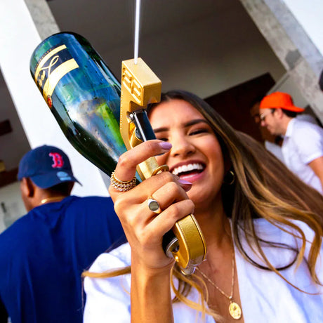 Woman spraying beer with beergun drink dispenser at party