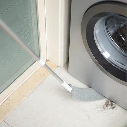 Flexible duster reaching underneath washer and dryer bottom gaps.