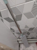 Duster reaching along wall baseboards and trim edges.