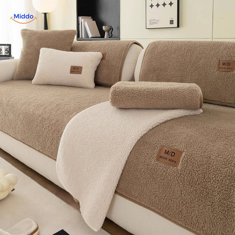Luxe faux lambswool sofa cover draped in beige with white wool blankets for cozy warmth.