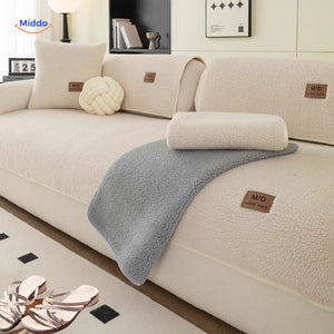 Elegant faux lambswool sofa cover in cream layered with neutral tone throws.