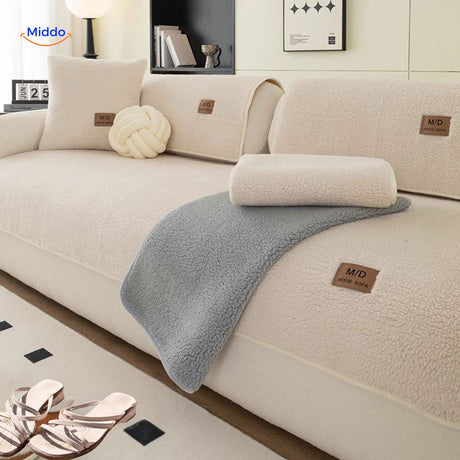Elegant faux lambswool sofa cover in cream layered with neutral tone throws.