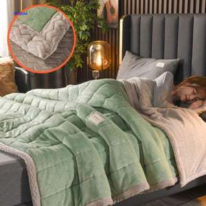 Green and grey two-tone wool blanket on bedding arrangement.