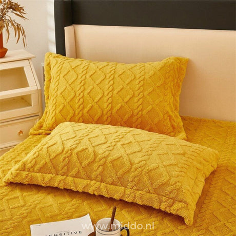 Fleece fitted sheet on fully made bed showing layering.
