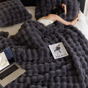 Fluffy winter blanket in black faux fur, showing soft plush texture.