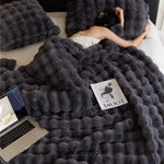 Fluffy winter blanket in black faux fur, showing soft plush texture.