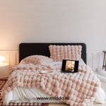Fluffy winter blanket in pink faux fur, perfect for soft home decor.