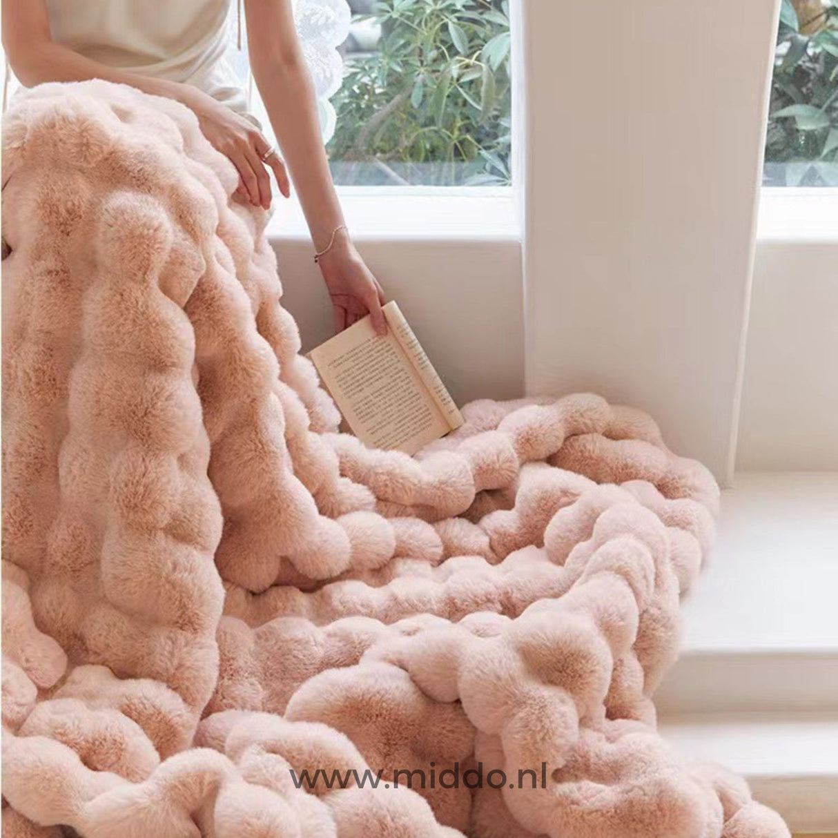 Person wrapped in fluffy winter blanket while reading, ultimate comfort.