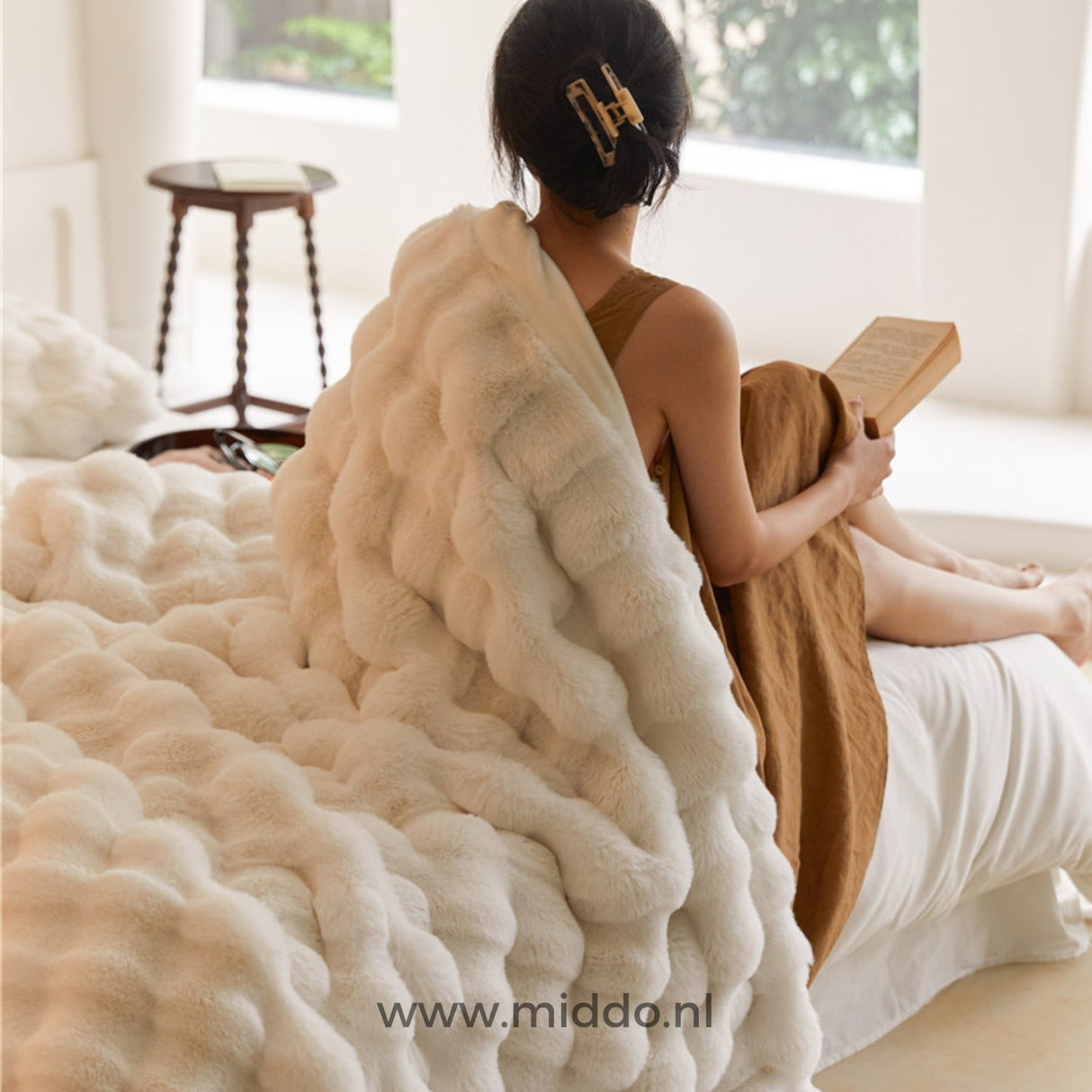 Fluffy faux fur blanket on sofa, draped for cozy room warmth.
