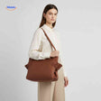 Women's foldable crossbody shopper bag in leather with adjustable shoulder strap.