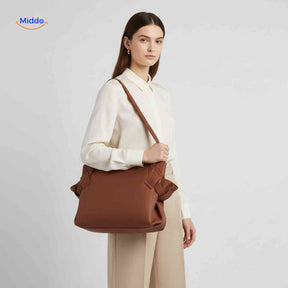 Women's foldable crossbody shopper bag in leather with adjustable shoulder strap.
