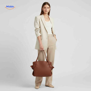 Foldable leather shoulder handbag with spacious interior and bow accent.