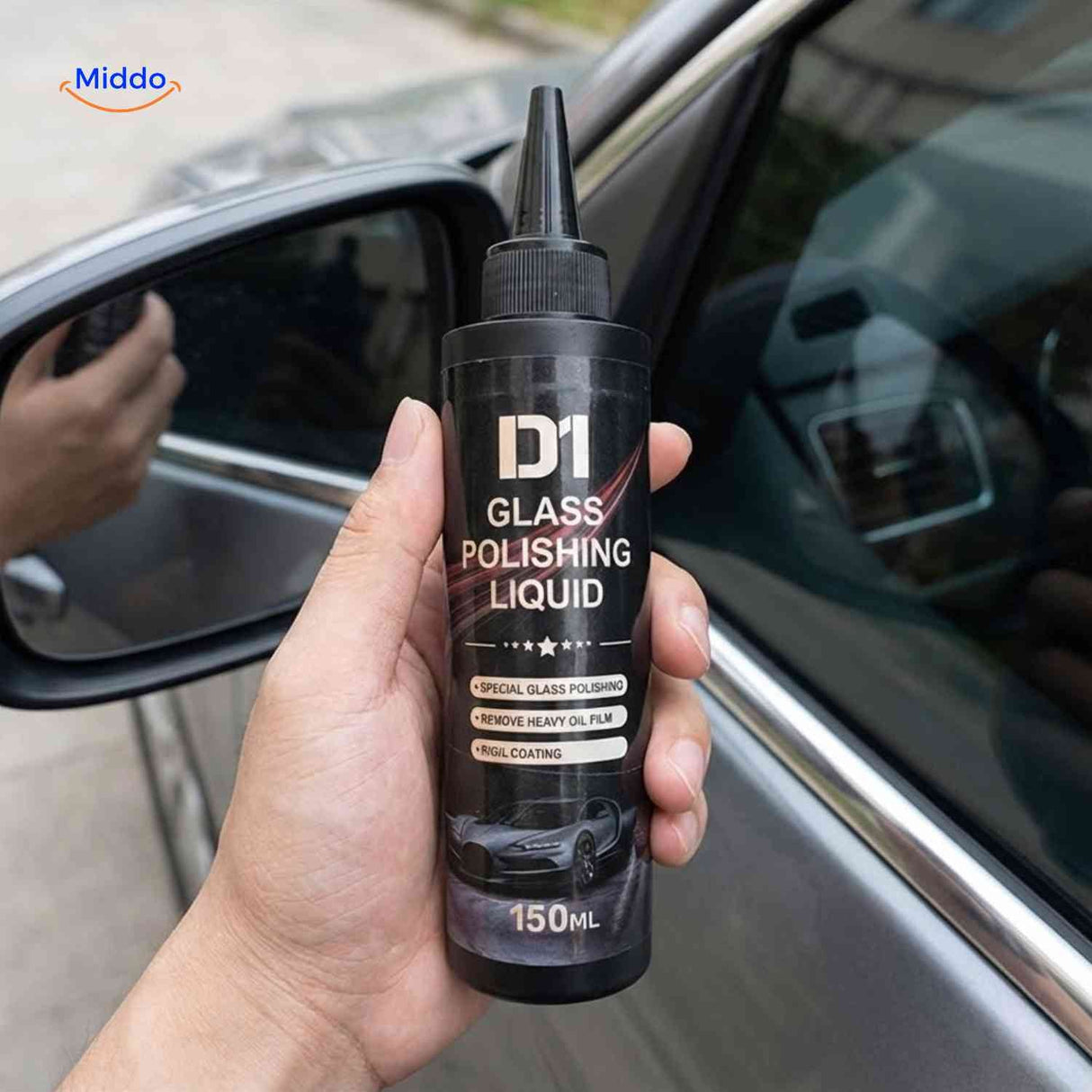 Glass polishing compound bottle held in hand ready for car window application.