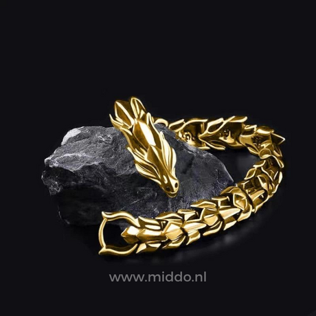 Gold dragon bracelet resting on a black stone surface, highlighting the warm metallic finish.