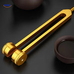 Gold healing tuning fork paired with therapeutic sound healing bowl.