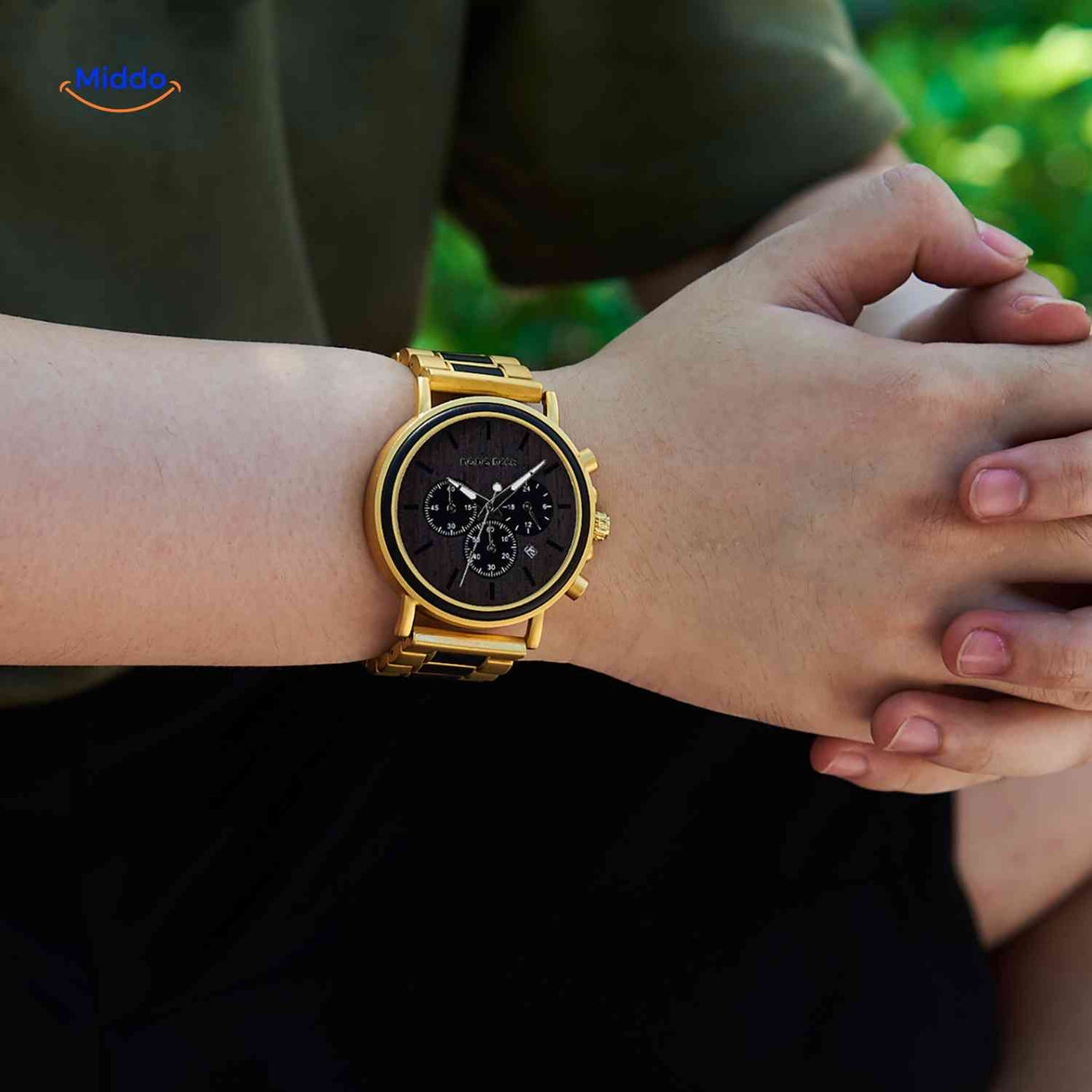 Golden wooden chronograph watch in lifestyle setting with warm lighting.
