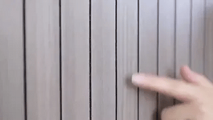 Grey wood-grain 3D wall panel displaying smooth flat-surface texture variation.