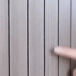Grey wood-grain 3D wall panel displaying smooth flat-surface texture variation.