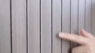 Grey wood-grain 3D wall panel displaying smooth flat-surface texture variation.