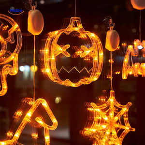 Halloween LED window lamps grouping pumpkin, witch hat, and spiderweb shapes in warm orange light.