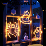 Halloween LED window lamps showing spider, witch hat, and ghost shapes glowing in a decorated window.
