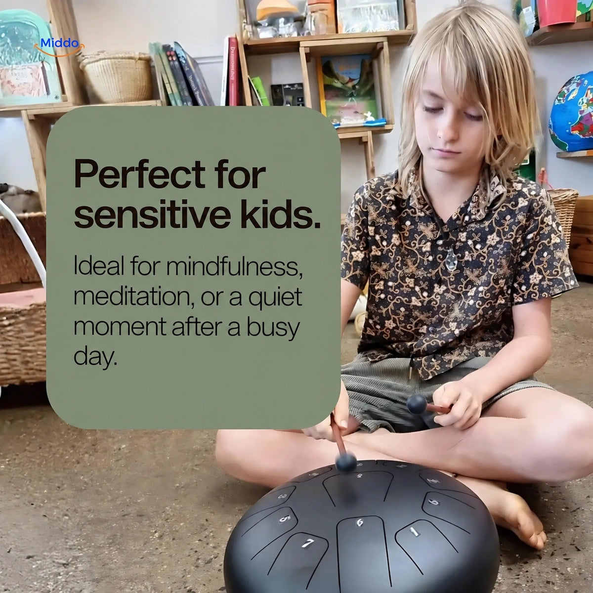 Child playing a black steel tongue drum with mallets during a quiet moment.