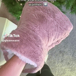 Person enjoying CozyPaws heated foot warmer during relaxation time.
