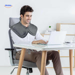 Person wearing heating pad at desk while working for improved neck and shoulder support.