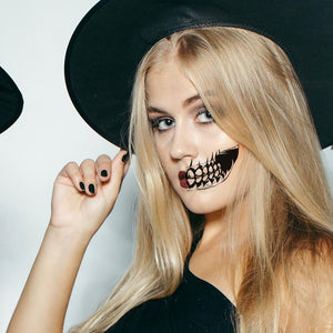 Witch wearing realistic grin temporary tattoo applied to cheek for Halloween.