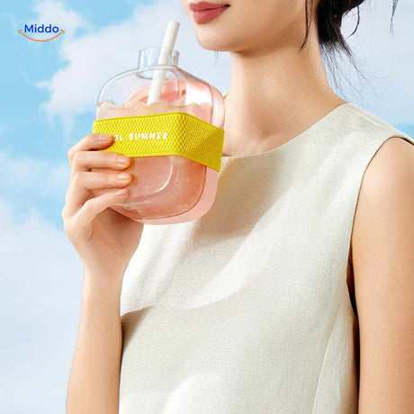 Pink ice bottle with summer drink and carrying strap, close-up view