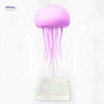 Glowing JellyGlow jellyfish lamp with clear glass base.
