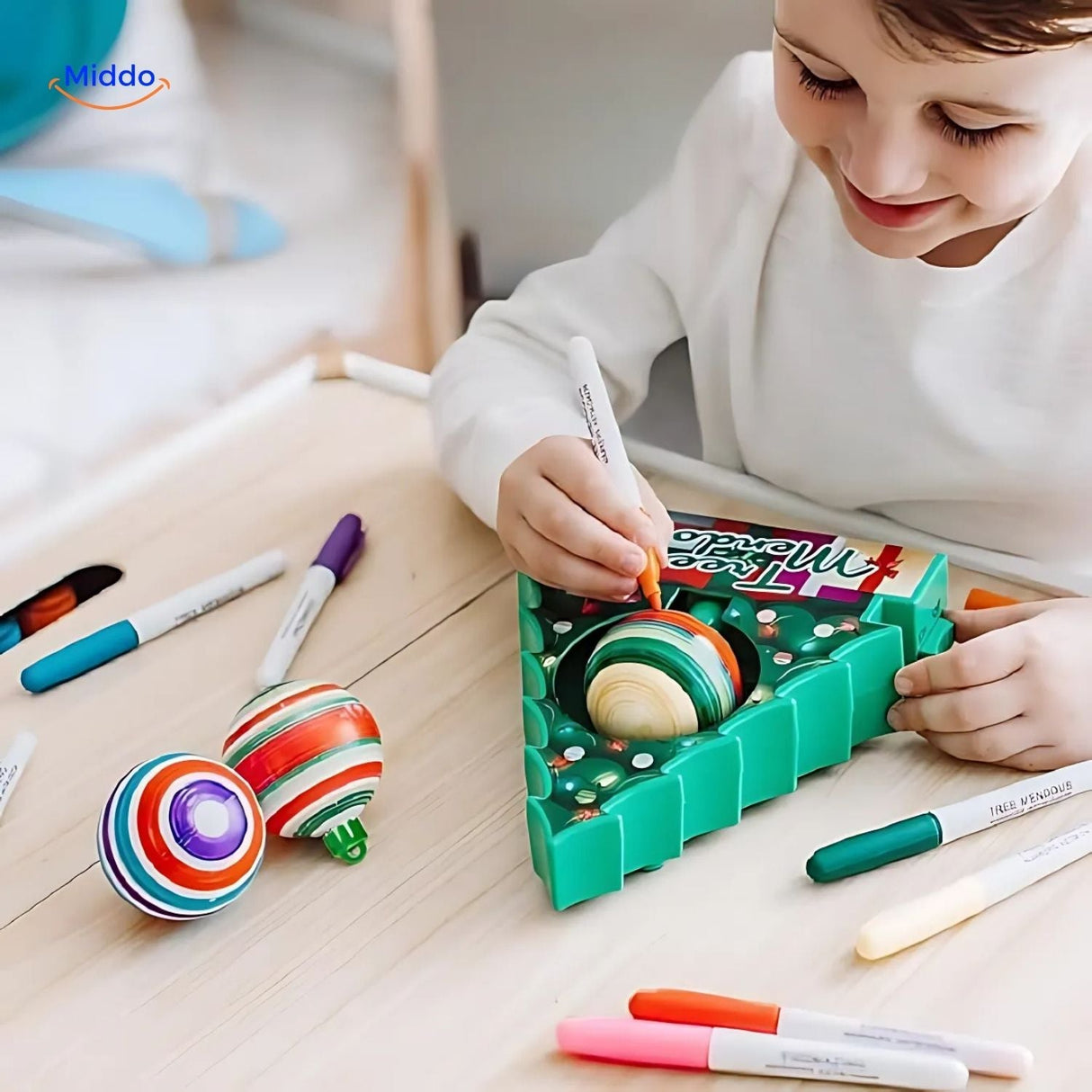 Child decorating a wooden Christmas ornament using the electric painting pen from the kit.
