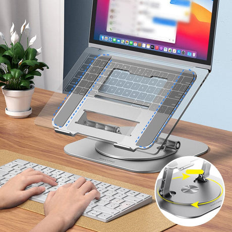 Adjustable 360 laptop stand styled with plants on a wooden desk workspace.