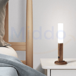 White motion-sensor LED lamp on bedside table providing warm nighttime light.
