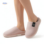 Woman wearing soft light pink non-slip cotton slippers.