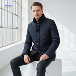 Man wearing quilted jacket seated indoors by window, showcasing fit and warmth.