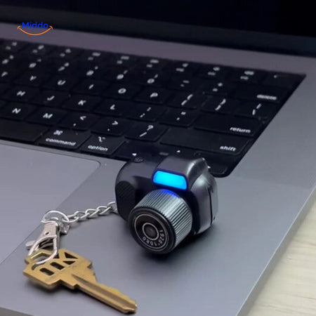 Compact mini camera as keychain accessory on laptop for easy portability