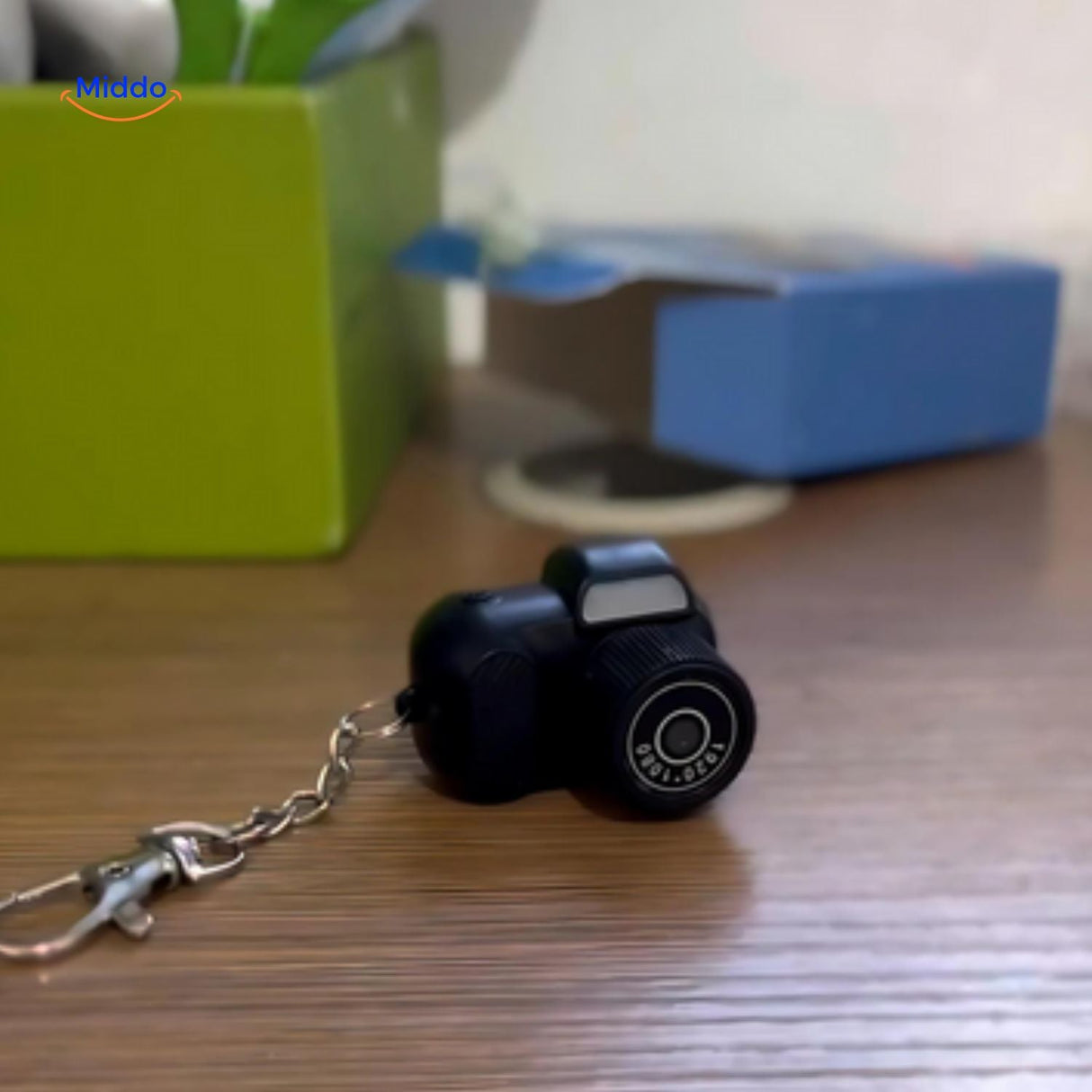 Portable mini camera balanced against earphone to show lightweight design
