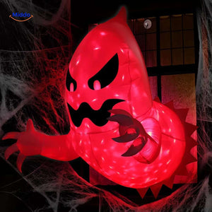 Spooky red-lit monster inflatable peeking through window with atmospheric lighting.