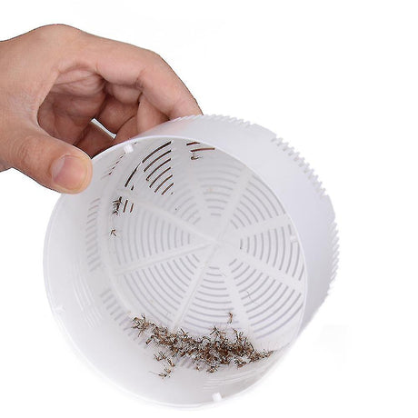 Compact electric mosquito trap shown in hand to demonstrate portable, chemical-free insect control.