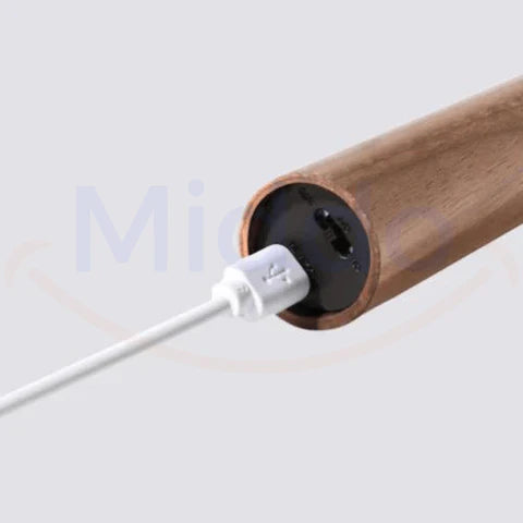 USB charging cable connected to motion-sensor LED lamp for battery recharging.